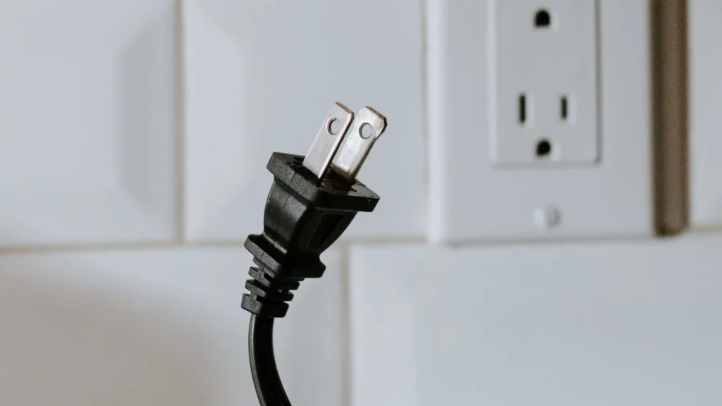 Picture of an electrical plug next to an electrical outlet for the blog Electrical Outlets Not Working